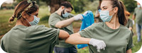 Volunteers cleaning up a park with masks on