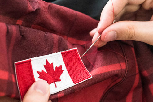 Sewing a Canadian flag onto clothing