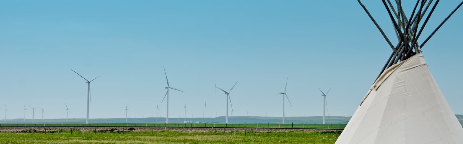 Image of tipi in front of windmill farm