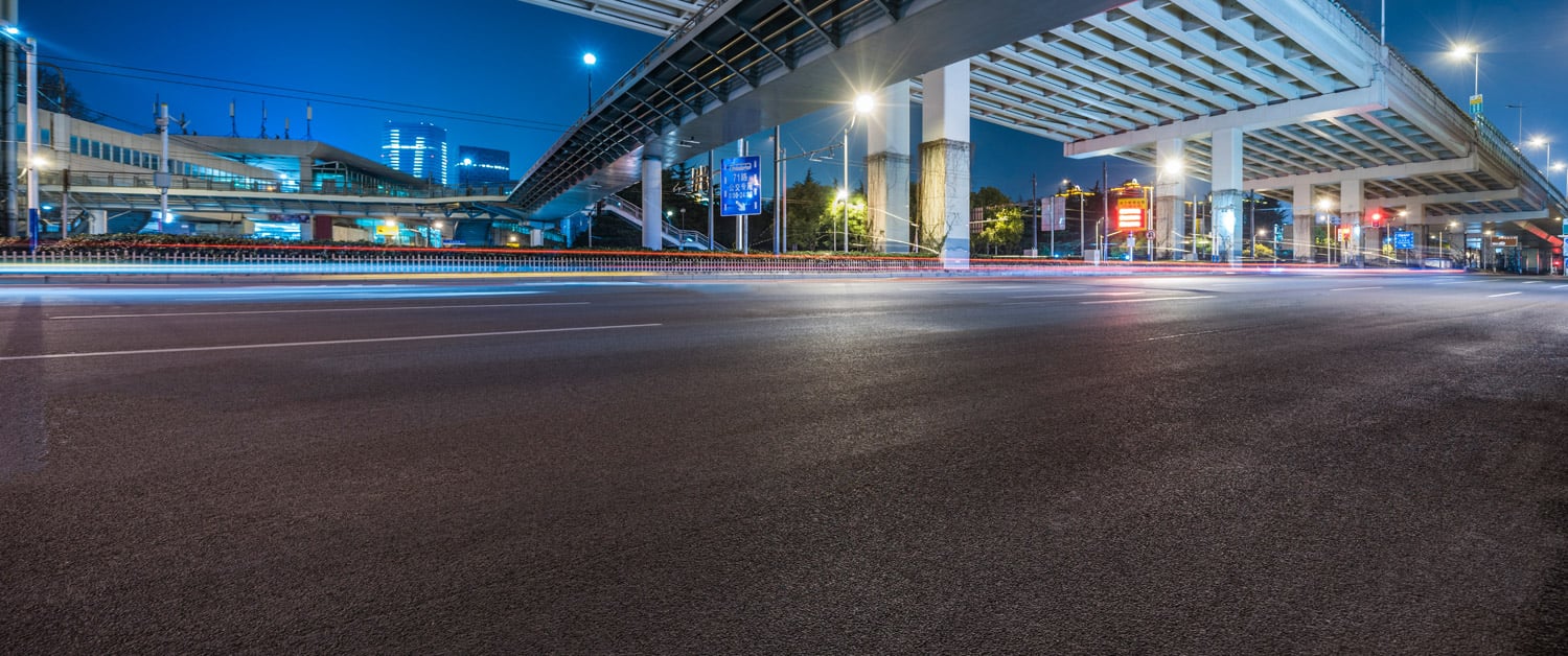 an empty road with a building in the background