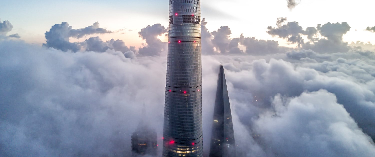 the top of an office tower poking through the clouds