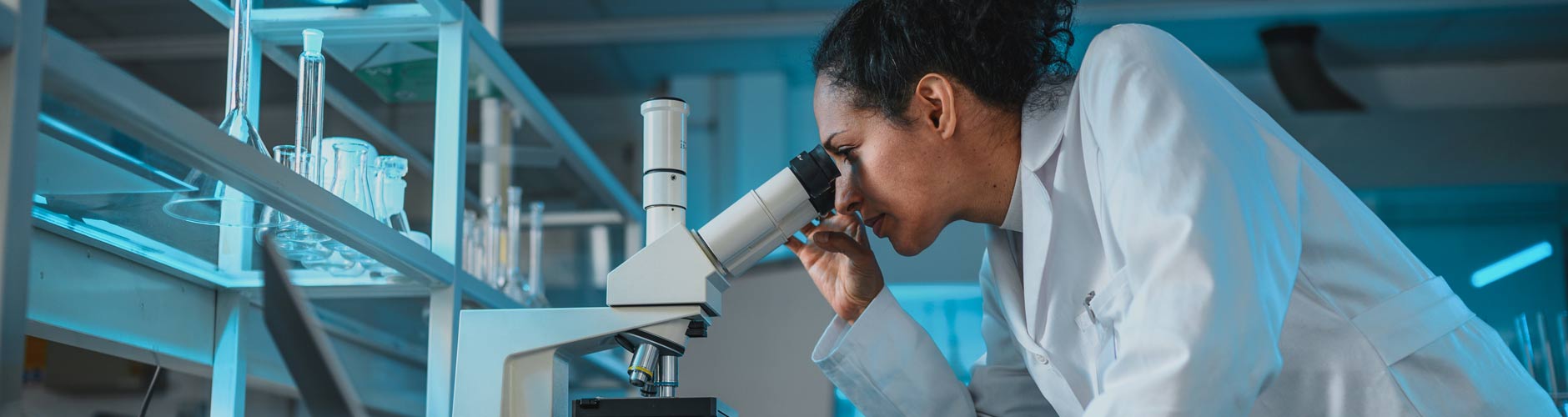 Lab technician looking in a microscope 