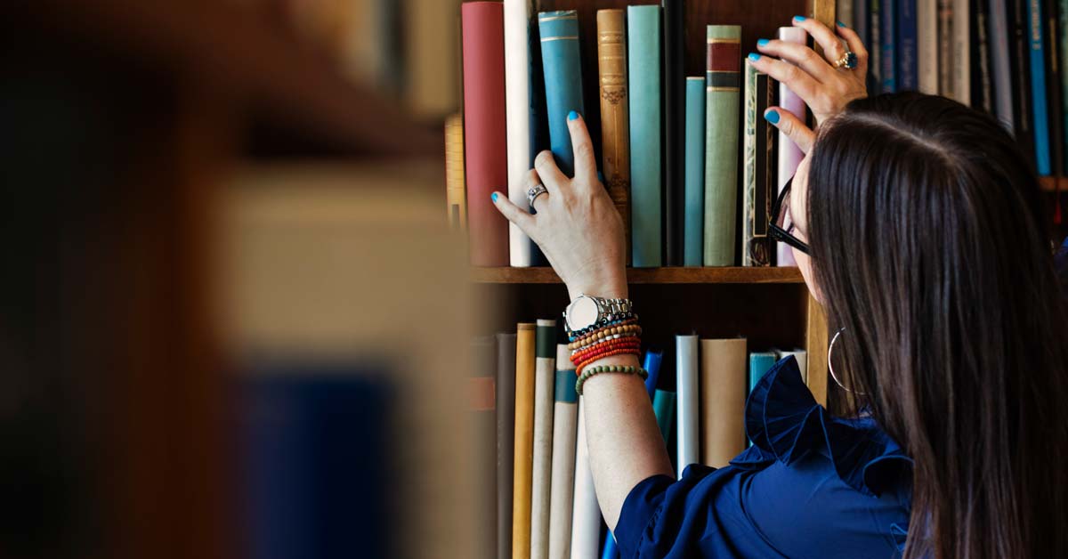 Woman looking at books on shelf 