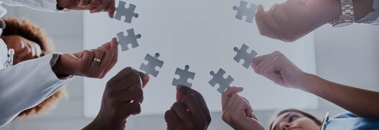 Health professionals holding puzzle pieces