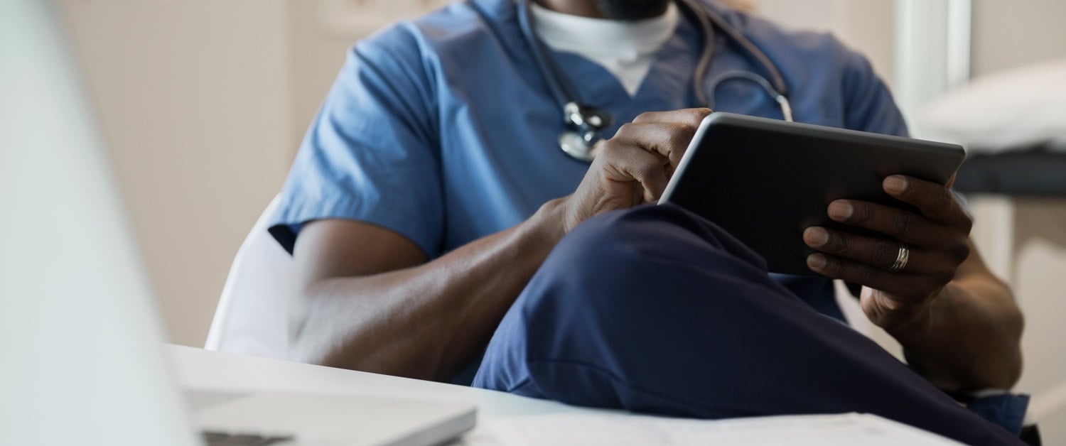 une personne assise à une table qui se sert d'un ordinateur portable